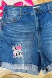 Blue denim shorts with a patch design on a textured surface