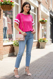 Woman in pink top and blue jeans standing on a street with shops in the background